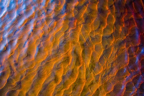Clear golden water stream pattern with sand waves under it Stock Photos