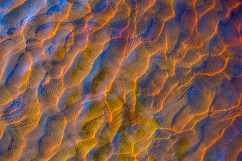 Clear golden water stream pattern with sand waves under it Stock Photos