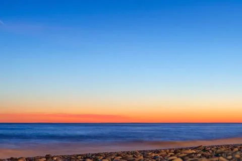 Clear gradient sky at sunset over the sea Stock Photos