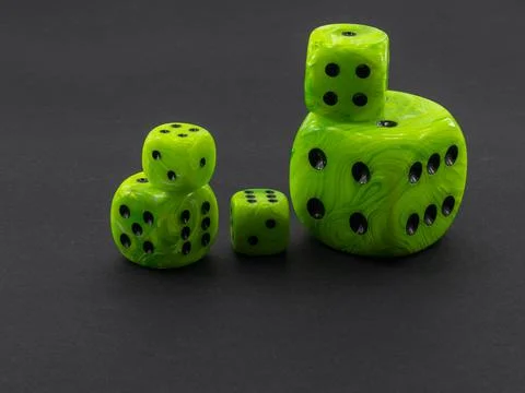 Clear green dice with different dimensions on black background Foto stock