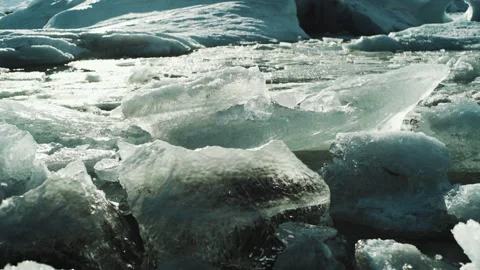 Clear ice chunks bobbing in a glacier lagoon close up in Iceland Vídeos de archivo 348026276
