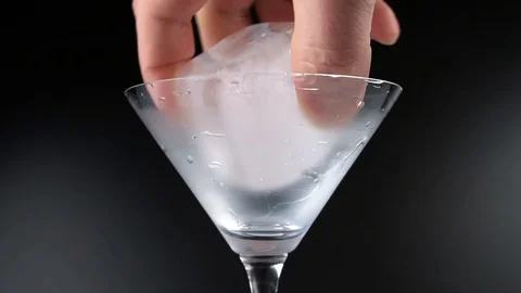 Clear ice cube spinning in a cocktail glass Stock Footage 126338176