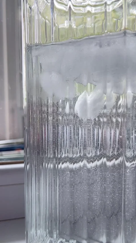 Clear ice cubes floating in glass of water macro video Stock Footage 336506980