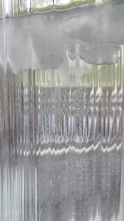Clear ice cubes floating in glass of water macro video Stock Footage 336506982