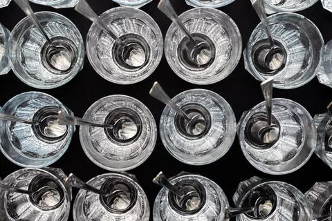 Clear latte glasses arranged in rows with metal spoons. Foto stock
