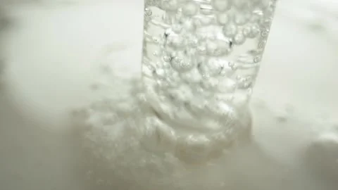 A clear liquid with bubbles is collected upwards through a glass vessel 库存影片 293737919