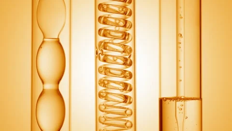 Clear liquid with bubbles rising in lab condensers yellow ramp Stock Footage 335222609