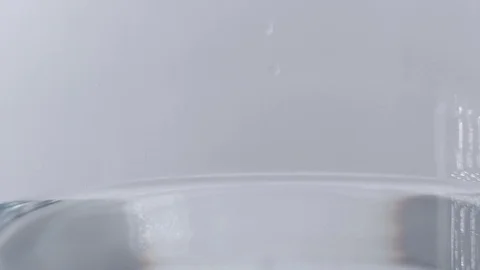Clear liquid filling up a clear container with bubbles. Slo-mo Stock Footage 114087135