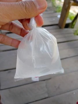 Clear liquid in a plastic bag held by a person outdoors during daytime Stock Photos