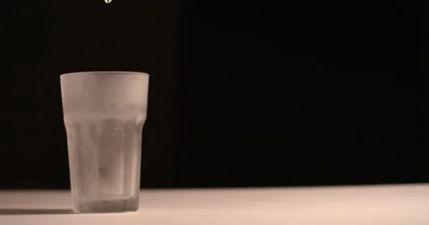 Clear liquid poured into Frosted glass-isolated background Stock Footage
