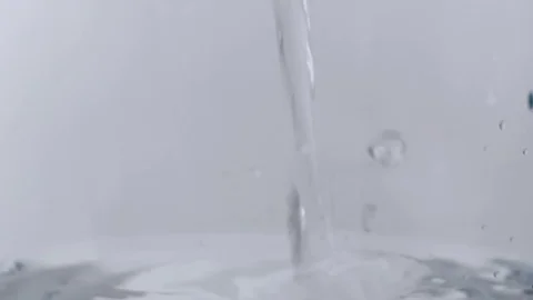 Clear liquid pouring into more clear lquid causing bubbles Stock Footage 114086483
