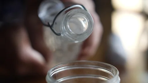 Clear liquid pouring from the neck of a bottle Stock Footage 85724709