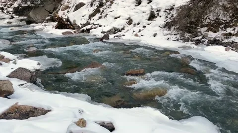 Clear mountain clear stream runs over the stones in winter Video stock 232653406