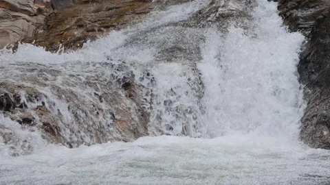 A clear mountain creek flows over mossy rocks, its gentle movement bringing a Stock Footage 312338259