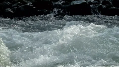 A clear mountain river flows rapidly through river rocks Video stock 320922991