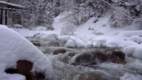 A clear mountain river runs through a snowy gorge Stock Footage 147401125