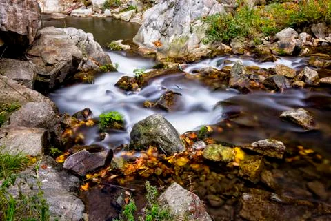 Clear mountain river with small waterfall Stock Photos