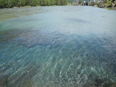 Clear mountain river with sun speckles on water Stock Footage 76642611