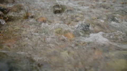 Clear mountain stream flowing over colorful rocks Stock Footage 331800608