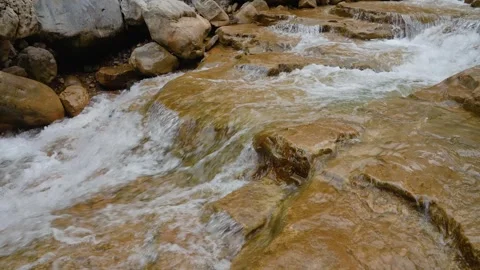 Clear Mountain Stream Flowing Over Smooth Layered Brown Rocks Video stock 342310333