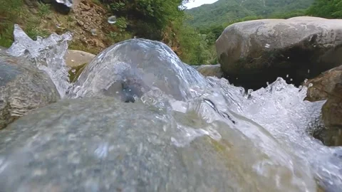 Clear mountain stream water flowing over big rock. Stock Footage 335711483