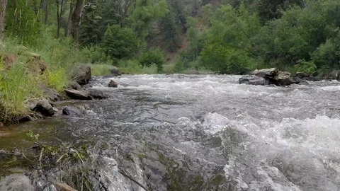 Clear mountain water flows down river, close up of the water splashing Stockbeeldmateriaal 93517384