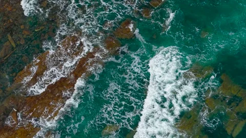 Clear ocean waves rolling over underwater rocks. Aerial view shows turquoise sea Stock Footage 311454608