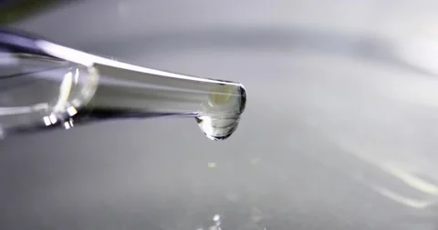 Clear oily liquid drips from pipette 4k movie Stock Footage 253379771
