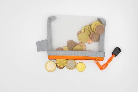 Clear orange pouch overflowing with euro coins and change Stockfoto's