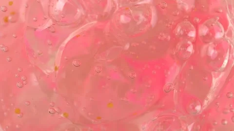 Clear pink gel fluid with bubbles, rotating. Macro texture of cosmetics produ Stock Footage 276482054