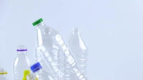 Clear plastic bottles on a white surface, awaiting recycling. Stock Photos
