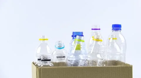 Clear plastic bottles on a white surface, awaiting recycling. Stock Photos