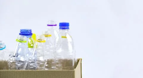 Clear plastic bottles on a white surface, awaiting recycling. Stock Photos