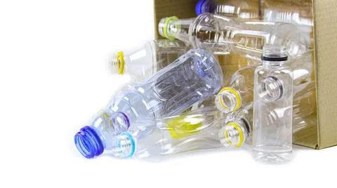 Clear plastic bottles on a white surface, awaiting recycling. Stock Photos