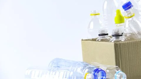 Clear plastic bottles on a white surface, awaiting recycling. Stock Photos