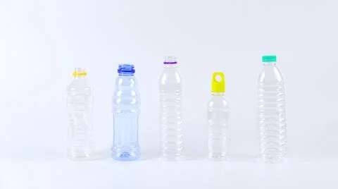 Clear plastic bottles on a white surface, awaiting recycling. Stock Photos