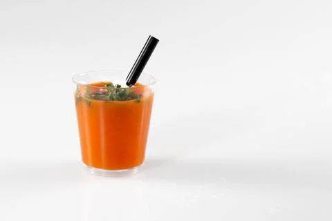 Clear plastic container filled cup tomato gazpacho soup with green pesto sa.. Foto stock