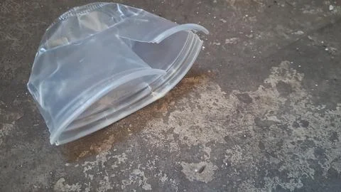 Clear plastic cup discarded on a rough gray concrete surface Stock Photos