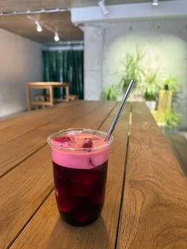 A clear plastic cup filled with a cold, dark red berry drink topped with Stock Photos
