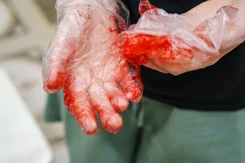 Clear plastic gloves covered in bright red hair dye close up Stock Photos