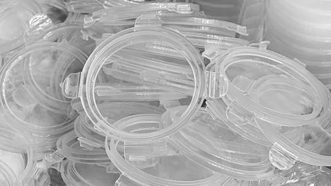 Clear plastic lids are piled haphazardly. plastic lids are stacked on top of  Stock Photos