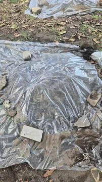 Clear plastic sheet covers scattered rocks and dirt Foto stock