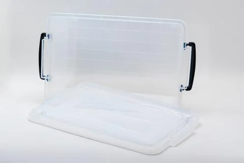 Clear plastic storage container with lid and handles for organizing items Stock Photos
