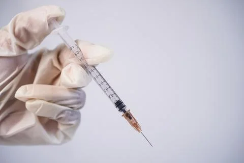 A clear plastic syringe with an open hypodermic needle positioned diagonall.. Stock Photos