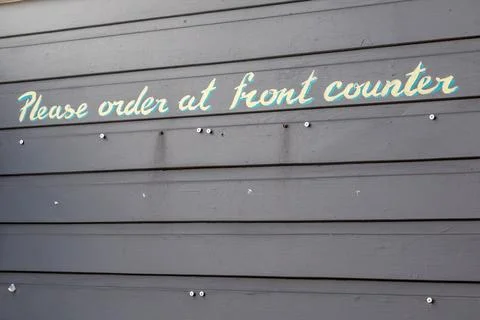 A clear “Please Order at Front Counter” sign mounted on a cafe wall Stock Photos