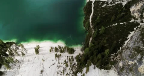 Clear pristine Lake in the Alps surrounded by trees and white beaches. Aerial Stock Footage 148532923