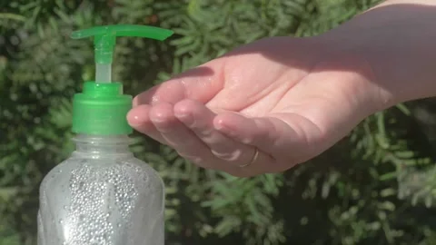 This is a clear pump bottle featuring a green cap set against a beautiful Video stock 280780441