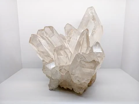 Clear quartz crystal cluster on white surface Stock Photos