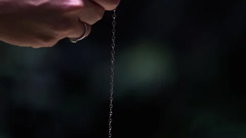 Clear quartz crystal pendulum hanging from Caucasian woman's hands Video stock 203866794