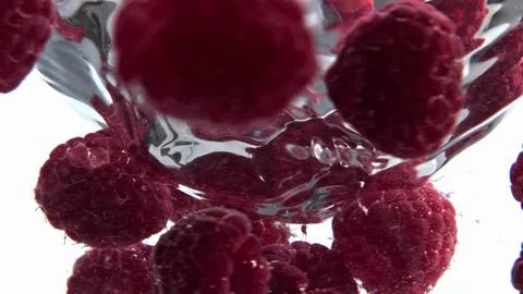 Clear raspberry beverage funnel inside glassware closeup. Cold cocktail spinning Photos